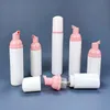 Weiße 30-ml-PET-Flasche mit schäumendem Reinigungsmittel und Schaumspender-Pumpe in Reisegröße. Seifenflaschen 30 ml mit rosa-weiß-roségoldener Schaumpumpe