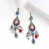 Ohrringe wie ein Fisch, hängend in verschiedenen Farben aus Metallquasten, eingelegt mit kleinen Perlen in Blau, Rot, Cyan, weiblicher baumelnder Kronleuchter