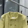 Nella primavera del giallo limone, un piccolo cappotto di tweed grossolano e profumato, una celebrità, in lana con bottoni dorati a doppio petto