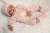 Ręcznie robiony 22-calowy lalek silikonowy odrodzony dziecko jest ubranym różową tkaninę piękną noworodka zabawka kłama i siedzi