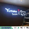 Außenwerbung, frontbeleuchtetes, individuelles Acrylschild mit Schriftzug für den Firmennamen des Salons, des Cafés, des Restaurants