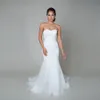 L'abito da sposa stile tromba presenta una vita scesa, una scollatura a cuore, una gonna in organza fluente e un abito da sposa in pizzo con cordoncino