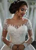 Incredibili abiti da sposa in tulle trasparente a maniche lunghe con scollo gioiello e abiti da sposa con applicazioni in pizzo con perline