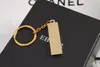 Der goldene Schlüsselanhänger in Form eines Ziegelsteins. Schlüsselanhänger aus reinem Gold mit Reinheitsgrad 9999. Simulation eines kreativen kleinen Geschenks aus Gold