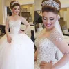 Luxury Crystals Beaded Ball Gown Wedding Dresses 2017 Modest Sheer Neck Illusion Long Sleeves Tulle Puffy Lace Up Backless Bridal Gowns