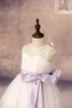 2017 Custom Flower Girl Dresses Lovely Sheer White Lace Jewel Neck Nätt A-Line Open Back Cute Lilac Bow Ribbon Communion Dress for Girls