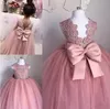 Abiti da ragazza di fiore rosa Abiti da spettacolo di tulle con applicazioni di pizzo senza maniche con collo gioiello trasparente Abiti da compleanno con fiocco grande