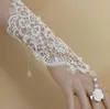 La robe de mariée de style tendance est accessoirisée avec un bracelet en dentelle blanche et une chaîne à anneaux, à la mode et élégante.