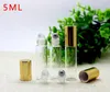 Venta al por mayor 1100 unids/lote 5 ML botellas de rodillo de vidrio transparente para aceites esenciales botella enrollable de Perfume con bola de rodillo de Metal y tapa dorada