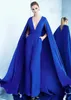 Dubai Royal Blue Jumpsuits Prom Klänningar med Caped Deep V Nacke Keyhole Back Formella Klänningar med Pocket Evening Wear Elegant Celebrity Dress