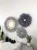 ノルディックポーチの創造的なリビングルームのソファとホームステイの装飾が付いている手編みの羽の鏡の壁の装飾的なプレート