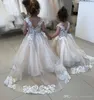 Nya eleganta spetsapplikation Flower Girl Dresses för bröllopsknappar Back Toddler Pageant -klänningar Tulle Sweep Train Kids Communion Dres273U