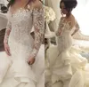 2024 Vestidos de novia de sirena de lujo Cuello transparente Manga larga Ilusión Volantes Botón con gradas Volver Capilla Tren Tallas grandes Vestidos de novia personalizados