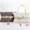 Taille 16 * 12 * 4.5 cm sac à main offre spéciale nouveau Style mariage oreiller forme boîte à bonbons avec nœud papillon coloré boîte-cadeau avec poignée en soie