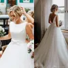 abiti da sposa personalizzati con collo gioiello e strascico con fiocco e fascia in tulle, abiti da sposa a linea a trapezio