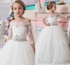 Ny Princess Flower Girls Dresses Bateau Neck Beaded Sash Lace Half Sleeves Pagant Klänningar Lång Golv Tulle Communion Dress