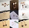 Wholesale- titanium steel black and white double-sided four-leaf clover cute small fish temperament elegant tassel earrings female fashio