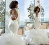 2019 Vestidos de novia de sirena modestos Mangas largas Sin espalda sexy Organza Encaje Apliques con gradas Falda con volantes Vestido de novia de boda