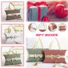 Taille 16 * 12 * 4.5 cm sac à main offre spéciale nouveau Style mariage oreiller forme boîte à bonbons avec nœud papillon coloré boîte-cadeau avec poignée en soie