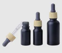 Botella de vidrio esmerilado de perfume de aceite esencial vape negro mate e botella de gotero de vidrio líquido 10 ml de plástico de grano de madera tapa de medición