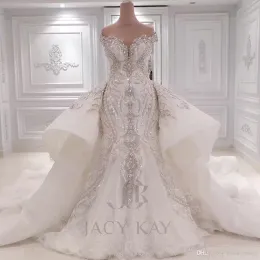 Luxuriöse Brautkleider im Meerjungfrau-Stil mit kristallbesetzter Spitze und schulterfreier Perlenapplikation und abnehmbarer Schleppe mit Pailletten