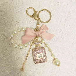 Pearl Chain nummer 5 flaska nyckelring för kvinna lyx smycken båge bil nyckelring camellia pärla hängsmycke nyckelringar väska dekoration aa220318