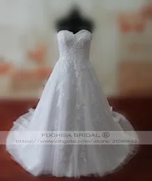 Abito da sposa lungo con scollo a cuore e applicazioni di perline con corsetto sul retro. Abito da sposa con finiture in pizzo