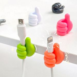 Venta al por mayor, gancho autoadhesivo para decoración de pared, gancho creativo para colgar llaves de pulgar de silicona, Clip para Cable de datos para el hogar/oficina, organizador de escritorio de alambre