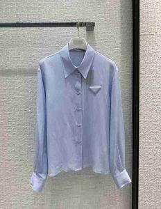 Blusas de mujer Diseñador de camisas Camisa de seda azul claro simple, elegante, capaz y hermosa, bolso triangular tridimensional, camisa con solapa de un solo pecho, mujer MUJ1
