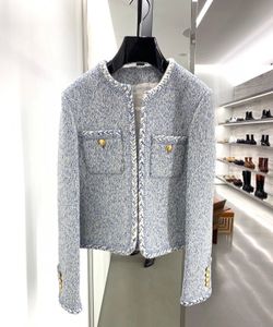 Un designer de luxe européen conçoit un nouveau tweed de sésame au début du printemps 2023 avec une veste tissée de chasse bleu glacier bouton doré