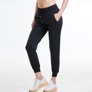 Femmes Tissus extensibles Coupe ample Sport Leggings skinny actifs avec deux poches latérales Pantalon à la cheville 201119