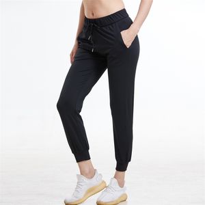 Femmes Tissus extensibles Coupe ample Sport Leggings skinny actifs avec deux poches latérales camo Pantalon à la cheville 211118