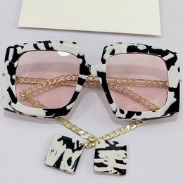 Lunettes de soleil Femmes 0722S Mode Classic Black and White Couleur Cadre Cadre Temple de chaîne en métal Pink Lens avec Pendentif Personnalité Lunettes sauvages Designer Anti UV400